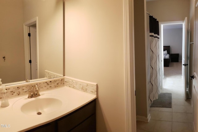 full bathroom with decorative backsplash, vanity, and tile patterned flooring