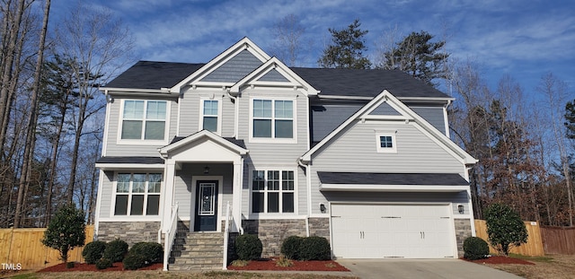 craftsman-style house featuring stone siding and fence