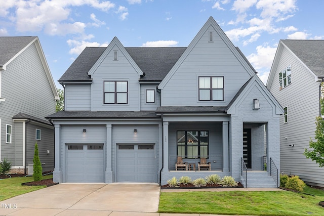 view of front of property with a shingled roof, covered porch, an attached garage, driveway, and a front lawn