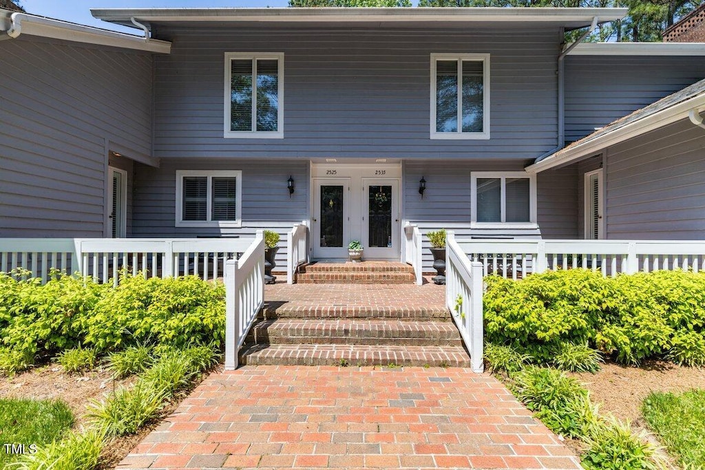 property entrance featuring a porch and french doors