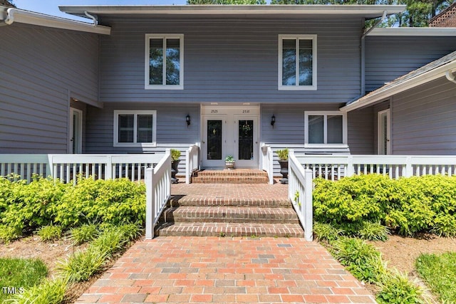 property entrance featuring a porch and french doors