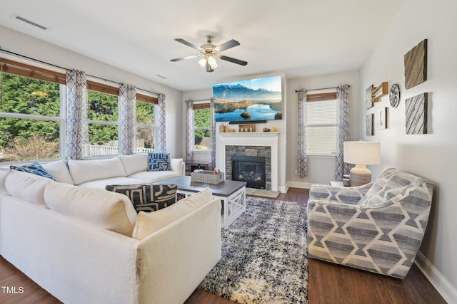 living area with wood finished floors, a fireplace, visible vents, and a healthy amount of sunlight