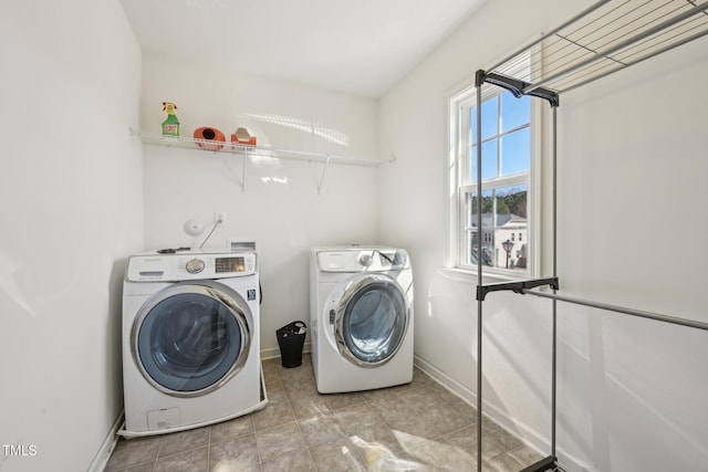 washroom featuring washer and dryer, laundry area, and baseboards