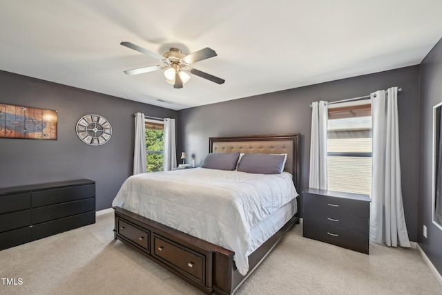 bedroom with a ceiling fan, baseboards, and light carpet