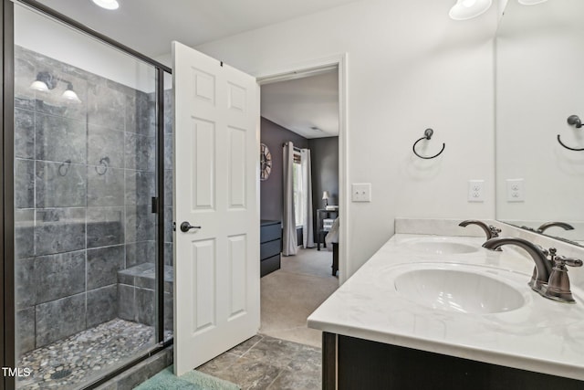 full bath featuring a shower stall, double vanity, and a sink