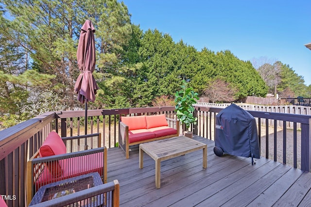 wooden deck featuring area for grilling and an outdoor living space