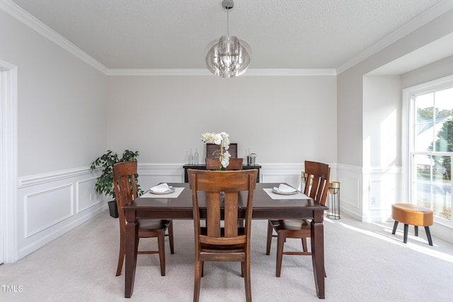 dining room featuring light carpet, ornamental molding, a textured ceiling, and a notable chandelier