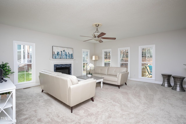 living area featuring light carpet, a textured ceiling, and a fireplace