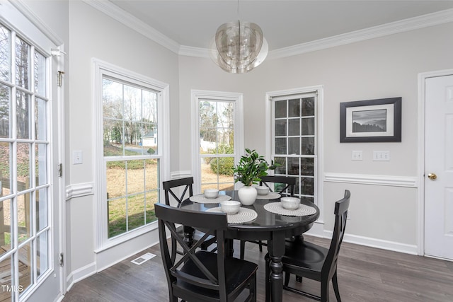 dining space featuring ornamental molding, plenty of natural light, and dark wood finished floors