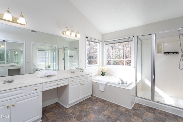 full bathroom featuring double vanity, a stall shower, plenty of natural light, and a sink