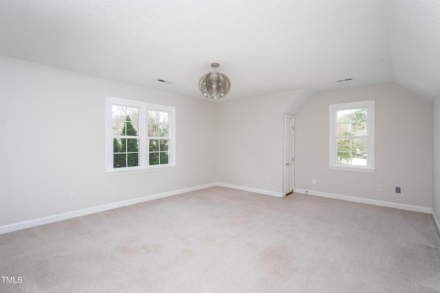 interior space with visible vents, a textured ceiling, and light colored carpet