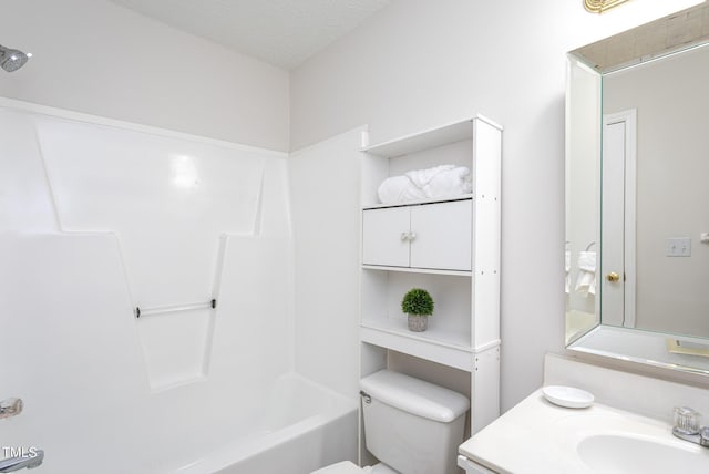 full bathroom featuring a textured ceiling,  shower combination, vanity, and toilet