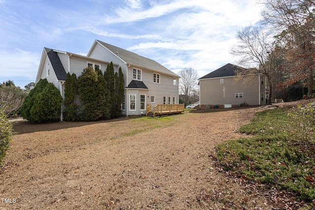 rear view of house featuring a wooden deck