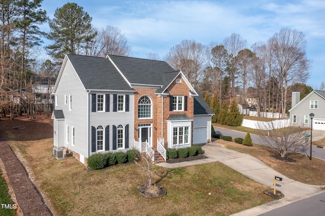 view of front facade featuring a garage, concrete driveway, a front lawn, and cooling unit