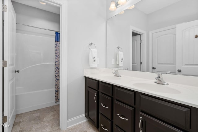 full bathroom with shower / tub combo, a sink, baseboards, and double vanity