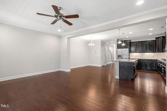 kitchen with dark wood finished floors, open floor plan, a kitchen island with sink, light stone countertops, and stainless steel fridge with ice dispenser