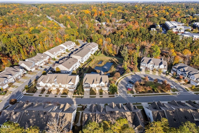 drone / aerial view featuring a residential view and a view of trees