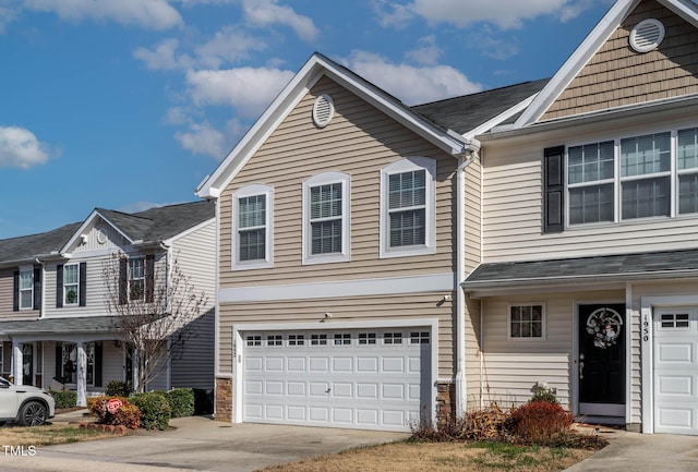 townhome / multi-family property featuring driveway and an attached garage