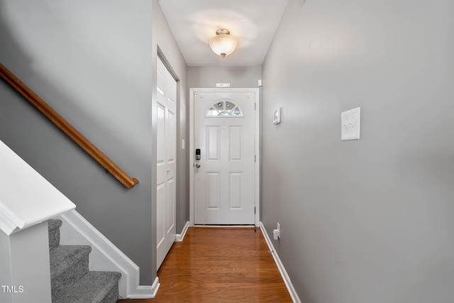 doorway featuring stairway, baseboards, and wood finished floors