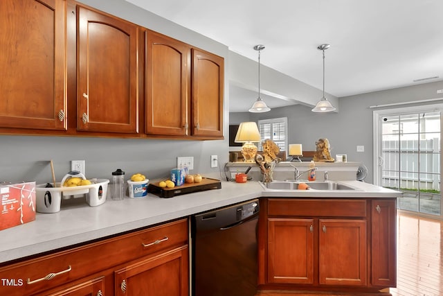 kitchen with a peninsula, a sink, a healthy amount of sunlight, black dishwasher, and light countertops