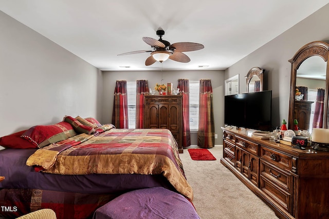 carpeted bedroom featuring ceiling fan and visible vents