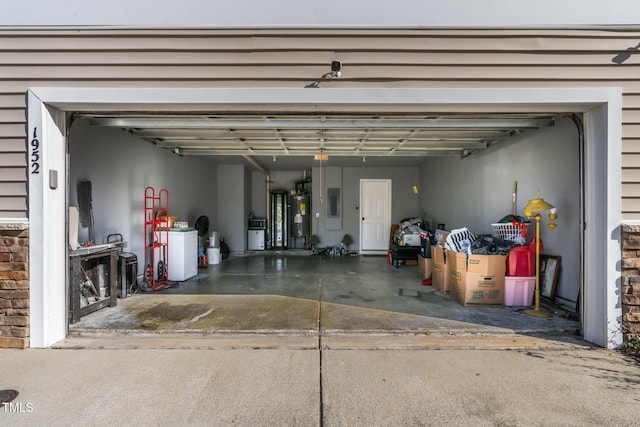 garage with electric panel, water heater, and separate washer and dryer