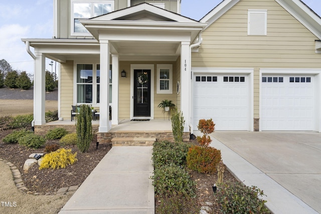 view of front of house with a garage, covered porch, and concrete driveway