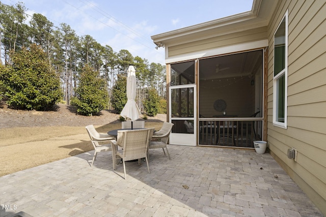 view of patio / terrace featuring a sunroom and outdoor dining space