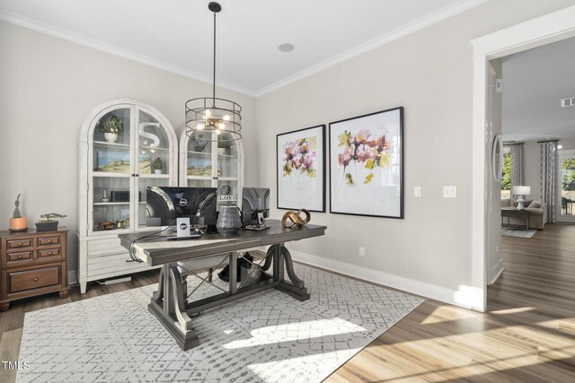 office area with baseboards, an inviting chandelier, wood finished floors, and crown molding