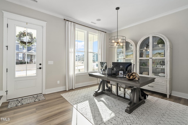 dining space featuring a healthy amount of sunlight, crown molding, and wood finished floors