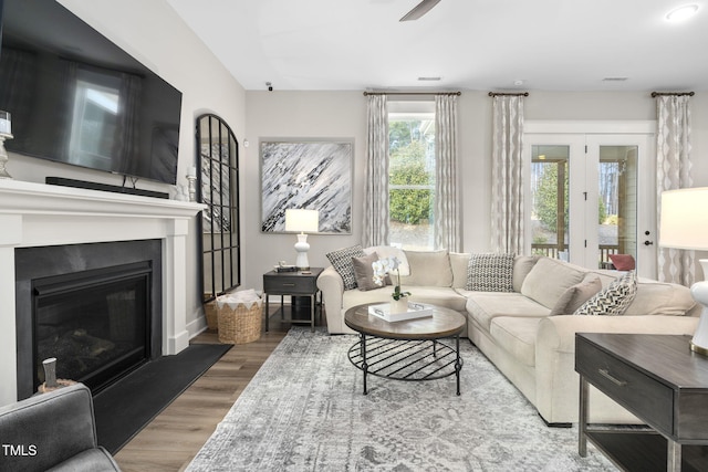 living area with wood finished floors and a glass covered fireplace