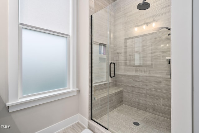 full bathroom featuring a shower stall and baseboards