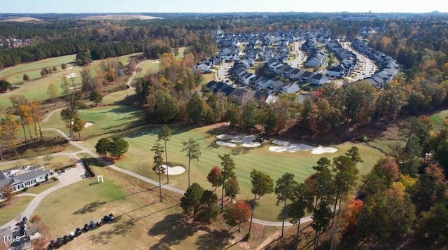 aerial view with view of golf course and a wooded view