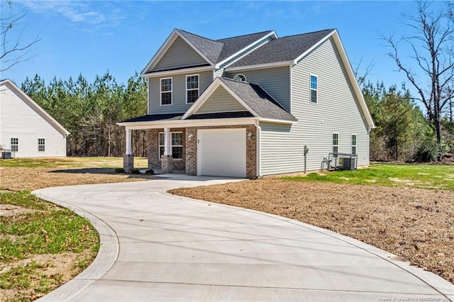 craftsman house featuring a garage, brick siding, a shingled roof, driveway, and a front yard