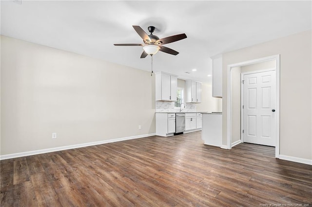 unfurnished living room with a sink, ceiling fan, baseboards, and dark wood-type flooring