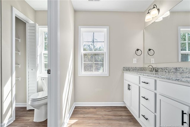 bathroom featuring toilet, wood finished floors, visible vents, vanity, and baseboards