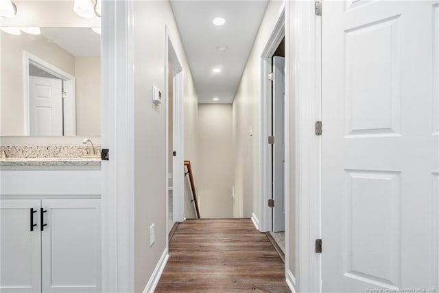 hallway with an upstairs landing, baseboards, dark wood-type flooring, and recessed lighting