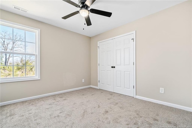 unfurnished bedroom with visible vents, baseboards, ceiling fan, carpet floors, and a closet