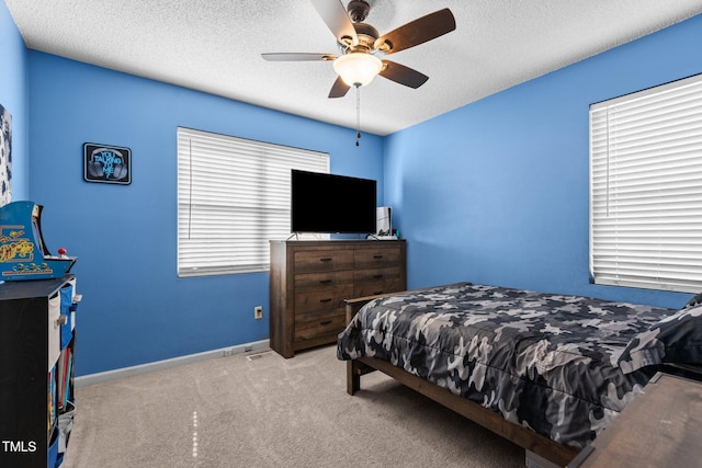 carpeted bedroom with ceiling fan, a textured ceiling, and baseboards