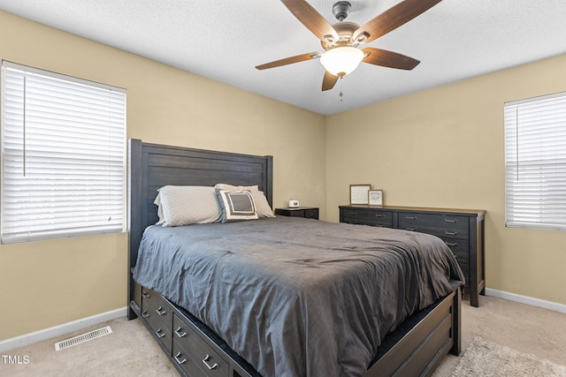 bedroom with baseboards, visible vents, and light carpet