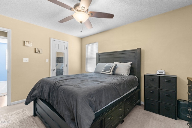 bedroom featuring a textured ceiling, ceiling fan, baseboards, and light carpet