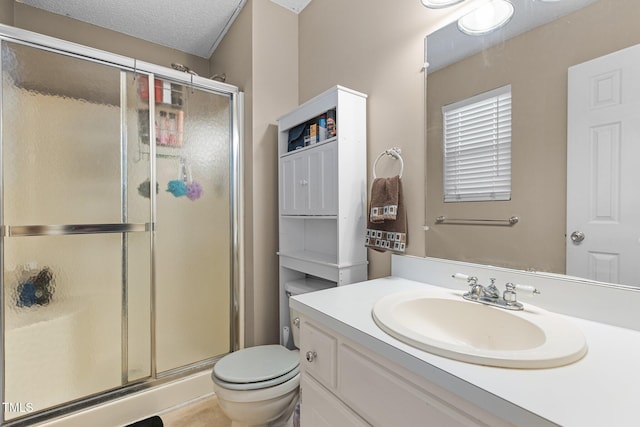 full bath featuring a textured ceiling, vanity, a shower stall, and toilet