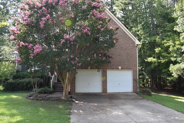 view of front of house featuring a garage, a front yard, and brick siding