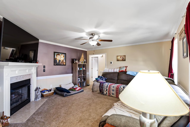 living room featuring carpet floors, a ceiling fan, a fireplace with flush hearth, and crown molding