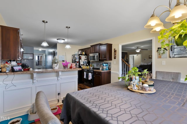 kitchen with black appliances, backsplash, dark brown cabinetry, a peninsula, and light countertops