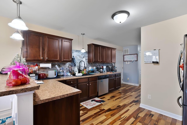 kitchen with visible vents, a sink, tasteful backsplash, stainless steel appliances, and dark brown cabinetry