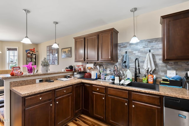 kitchen featuring a peninsula, a sink, light countertops, dark brown cabinetry, and dishwasher