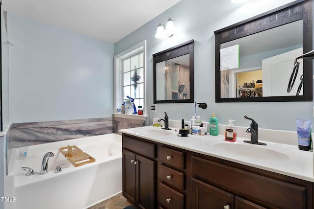 bathroom featuring a walk in closet, double vanity, a bath, and a sink