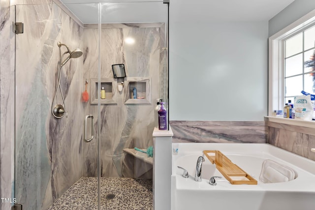 full bathroom featuring a bath and a marble finish shower