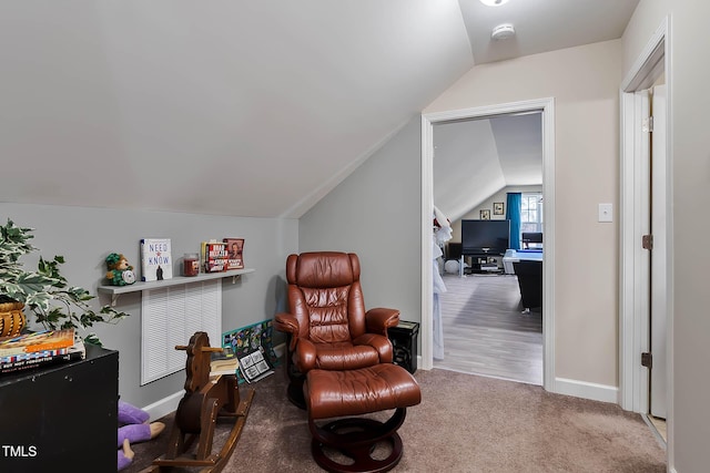 sitting room featuring baseboards, lofted ceiling, and carpet